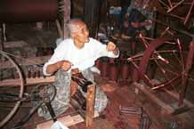 to Jpeg 46K 9809R14 Winding the spools for weaving cloth for monks' clothing in a house off a waterway at the back of the floating market at Ywa-ma- Lake Inle, Shan State.