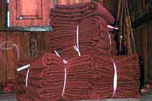 to Jpeg 54K 9809R17 Bales of cloth for monks' clothing in a house off a waterway at the back of the floating market at Ywa-ma- Lake Inle, Shan State.