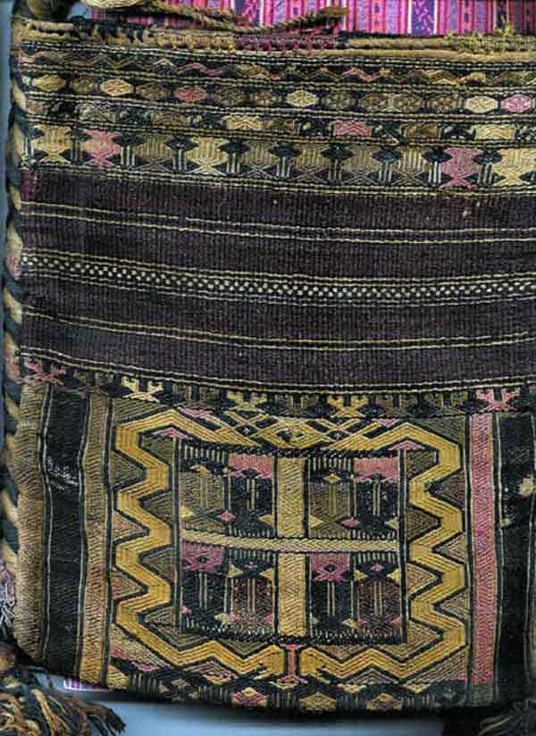 Jpeg 58K A detail of a bag in the collection of Bill Hornaday. He describes the main body of the bag as densely woven silk. The braided strap is cotton. He believes that most of the dyes are vegetable, except for some very faded methl violet. He is pretty confident that the reds are lac or madder but that the pink accents are faded chemically died silk. 