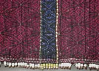 to Jpeg 51K Khumi woman's tubeskirt - detail showing the black warp and red (and light blue) supplementary weft patterning