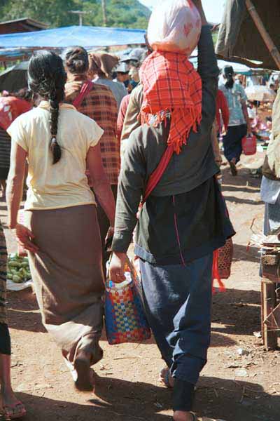 35K Jpeg 9809H33 Pa'O woman walking through Kalaw 5-day market, Shan State. This was the only Pa'O woman that I saw wearing leggings under her longyi. Also note the embroidered seam down the back of her blouse showing beneath her short jacket. 