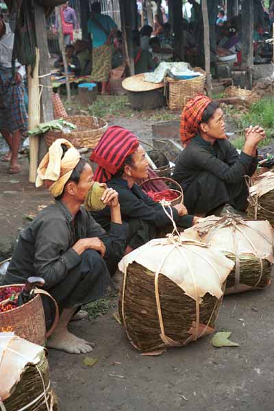 31K Jpeg 9809N03 Pa'O women at Nampan 5-day rotating market, Lake Inle, Shan State with their piles of thanapet leaf from cordia trees used to rolling around the local cheroots. 