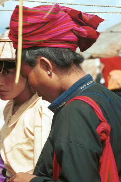 22K Jpeg 9809N25 Pa'O woman at Nampan 5-day rotating market, Lake Inle, Shan State with a finely made jacket with selvedge woven lettering inset into the collar. Her striped woven head-cloth matches her shoulder bag.