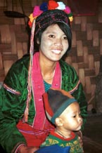 to 69K Jpeg A Silver Palaung woman and her young child in Pein Ne Bin village near Kalaw, northwestern Shan State. He is wearing a hat made of what appears to be felted fabric in different colours. His mother is wearing a cap usually worn young girls and unmarried women. The fabric in her blouse is typical of the shiny, velour fabrics which are currently popular. Note the embroidered seams where the sleeves are set into the blouse and which are also decorated with sequins.