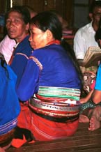 to 76K Jpeg Silver Palaung women in the Buddhist temple at Pein Ne Bin village near Kalaw, northwestern Shan State joining in the prayers on the day after the full moon 'Full Moon Day". They are wearing traditional hand woven tube skirts, embroidered blouses of a slightly shiny fabric and the Silver Palaung identifying bamboo or rattan hoops. The woman in the centre of the photo is also wearing a white metal belt. A white sash and black silky threads can also been seen amongst the hoops.