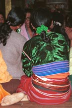 to 80K Jpeg A Silver Palaung woman in the Buddhist temple at Pein Ne Bin village near Kalaw, northwestern Shan State joining in the prayers on the day after the full moon 'Full Moon Day". She is wearing a traditional hand woven skirt, embroidered shiny velvet blouse and the Silver Palaung identifying bamboo or rattan hoops. There are also glimpses of a white sash and also dark silky threads tied around the waist.