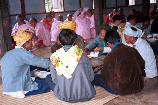 68K Jpeg The communal meal on the 'Full Moon day' festival in the Silver Palaung village of Pein Ne Bin, near Kalaw, southwestern Shan State - the monks and the men of the village. The men in the foreground are probably some of the senior men of the village. The monks are seen eating in the background.