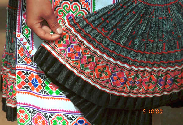 Examining a batik skirt the top part of which is in the Clean Water Miao style but has added strip of embroidery rather like the Red Hat Miao - Da Shu Jia village, Xin Zhou township, Longlin county, Guangxi province 0010i35.jpg