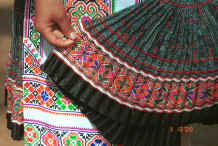 Jpeg 53K Examining a batik skirt the top part of which is in the Clean Water Miao style but has added strip of embroidery rather like the Red Hat Miao - Da Shu Jia village, Xin Zhou township, Longlin county, Guangxi province 0010i35.jpg