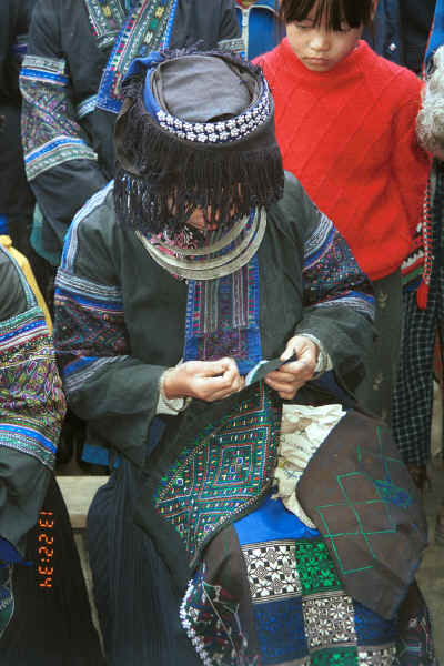 Black Miao girl demonstrating her embroidery on a piece for a woman's jacket - Dai Lo village, Shi Zi township, Ping Ba county, Guizhou county 0010z27.jpg