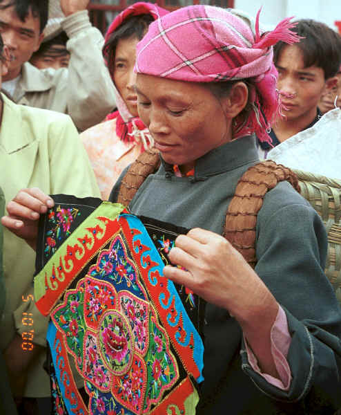 Miao woman showing the centre of baby carrier which she had made and was bringing in to sell to a stall-holder at the market.  She indicated that she was Clean water Miao.  De Wo market, De Wo township, Longlin county, Guangxi provinc 0010g10.jpg