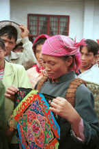 Jpeg 47K Miao woman showing the centre of baby carrier which she had made and was bringing in to sell to a stall-holder at the market.  She indicated that she was Clean water Miao.  De Wo market, De Wo township, Longlin county, Guangxi province. 0010g10.jpg