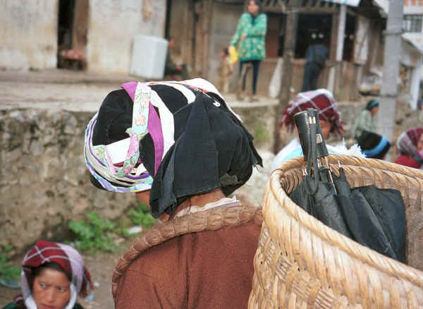 Side comb Miao woman with an umbrella in her back basket at De Wo market, De Wo township, Longlin county, Guangxi province 0010g29.jpg