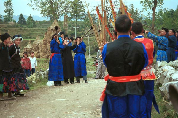 Jpeg 56K 0110D19  Villagers welcoming us to Gan He village, Ya Rong township, Huishui county, Guizhou province, south-west China. Musicians led by men playing on large lusheng pipes and followed by men blowing on very long (and loud) trumpets. The people living in this village are known as Qing Miao. There has been much intermarriage between Miao and Bouyei which is evident from the costume of the women. 