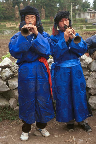 Jpeg 56K  0110D31 Two trumpeters as part of our welcome to Gan He village, Ya Rong township, Huishui county, Guizhou province, south-west China. The people living in this village are known as Qing Miao. There has been much intermarriage between Miao and Bouyei which is evident from the costume of the women.