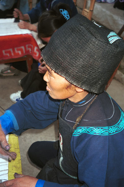 Jpeg 54K  0110E20 A Qing Miao woman demonstrating wax resist in Gan He village, Ya Rong township, Huishui county, Guizhou province. This is a Qing Miao (or Bouyei/Miao as there has been much intermarriage and the costume is very mixed). Her bib apron looks very similar to some Bouyei aprons.