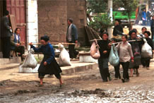 to Jpeg 87K Miao women trying to avoid the mud as they carry their produce down the main street in Bai Jin township, Huishui county, Guizhou province 0110C02