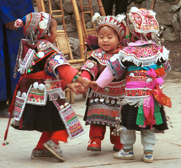 Jpeg 125K Iron beating Miao festival costume in miniature worn by little girls dancing in Gao Zhai village, Bai Jin township, Huishui county, Guizhou province. Note the finely gathered hat crown worn by the little girl on the right and shown in closeup in photos further down in the photo gallery 0110C08