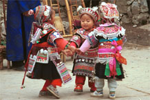 to Jpeg 125K Iron beating Miao festival costume in miniature worn by little girls dancing in Gao Zhai village, Bai Jin township, Huishui county, Guizhou province. Note the finely gathered hat crown worn by the little girl on the right and shown in closeup in photos further down in the photo gallery 0110C08