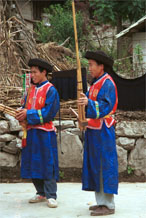 to Jpeg 165K Lusheng musicians waiting to play against a backdrop of woven, striped indigo skirts, Gao Zhai village, Bai Jin township, Huishui county, Guizhou province 0110C10