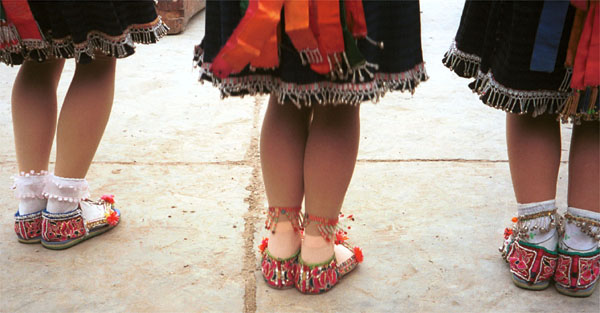 Jpeg 58K Back view of Iron beating Miao women whilst they dance showing their embroidered shoes, Gao Zhai village, Bai Jin township, Huishui county, Guizhou province. Unfortunately it is becoming unusual to still see hand made shoes rather than ubiquitous trainers on the dancers' feet 0110C13