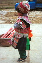 to Jpeg 139K Iron beating Miao festival costume in miniature worn by one of little girls who danced for us in Gao Zhai village, Bai Jin township, Huishui county, Guizhou province. Her costume is finely made. Note the beautifully woven and subtle woven striped indigo skirt that she is wearing which is a perfect miniature version of the adult woman's skirt 0110C16