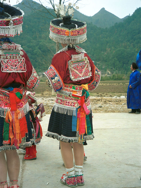 Jpeg 158K Back view of Iron beating Miao women's costume in Gao Zhai village, Bai Jin township, Huishui county, Guizhou province against the backdrop of the farm land and mountains rising from the narrow valley 0110C17