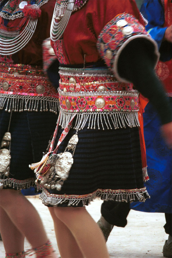 Jpeg 143K Close-up of Iron beating Miao women's costume in Gao Zhai village, Bai Jin township, Huishui county, Guizhou province showing the finely woven, striped skirt and the brightly embroidered braids around the waist 0110C20