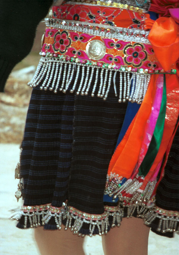 Jpeg 133K Close-up of Iron beating Miao women's costume in Gao Zhai village, Bai Jin township, Huishui county, Guizhou province showing the finely woven, striped skirt and the brightly embroidered braids around the waist 0110C21