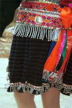 to Jpeg 133K Close-up of Iron beating Miao women's costume in Gao Zhai village, Bai Jin township, Huishui county, Guizhou province showing the finely woven, striped skirt and the brightly embroidered braids around the waist 0110C21