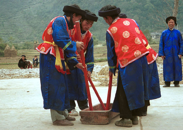 Jpeg 82K Miao men dancing and simulating stirring sticky rice in Gao Zhai village, Bai Jin township, Huishui county, Guizhou province against the backdrop of the farm land in the narrow valley 0110C25