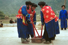 to Jpeg 82K Miao men dancing and simulating stirring sticky rice in Gao Zhai village, Bai Jin township, Huishui county, Guizhou province against the backdrop of the farm land in the narrow valley 0110C25