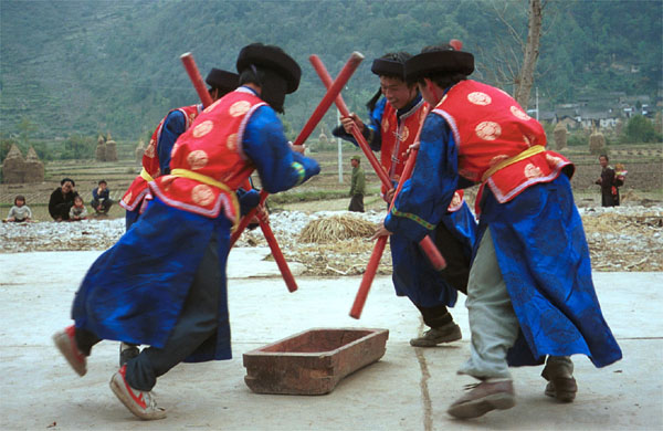 Jpeg 78K Miao men dancing and simulating stirring sticky rice in Gao Zhai village, Bai Jin township, Huishui county, Guizhou province against the backdrop of the farm land in the narrow valley 0110C26