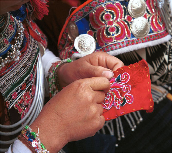 Jpeg 104K Iron beating Miao women in Gao Zhai village, Bai Jin township, Huishui county, Guizhou province working on some embroidery and wearing their festival costume 0110C29