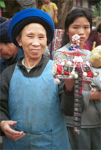 to Jpeg 129K Iron beating Miao woman holding the girl's finely pleated hat which I have just bought in Gao Zhai village, Bai Jin township, Huishui county, Guizhou province 0110D08