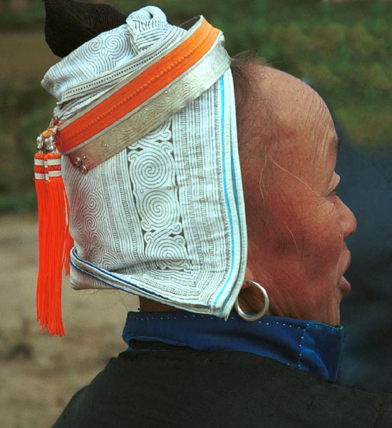 Jpeg 58K 0100F29 Gejia woman showing her headdress. The fabric is a machine printed reproduction of a traditional Gejia wax resist design. All the women in this village seemed to be wearing the commercially printed fabric and we did not see any original wax resist being worn on headdresses. Ma Tang village, Kaili City, Guizhou province. 