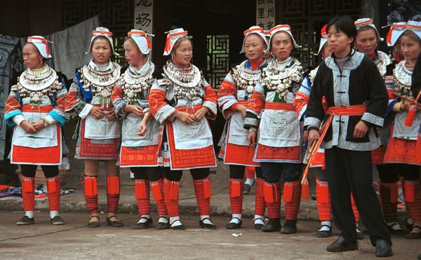 Jpeg 57K 0111G09 Gejia dance troupe performing in Ma Tang village, Kaili City, Guizhou province in November 2001. The apparently wax resist fabric in their costume - at least the headdress, apron and sleeves of the blouse - are now generally made from commercially printed fabric which imitates the Gejia traditional wax resist designs. 