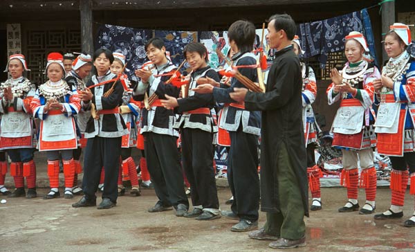 Jpeg 57K 0111G10 Gejia dance troupe performing in Ma Tang village, Kaili City, Guizhou province in November 2001. The apparently wax resist fabric in their costume - at least the headdress, apron and sleeves of the blouse - are now generally made from commercially printed fabric which imitates the Gejia traditional wax resist designs.