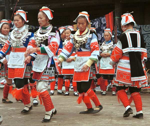 Jpeg 62K 0111G13  Gejia dance troupe performing in Ma Tang village, Kaili City, Guizhou province in November 2001. The apparently wax resist fabric in their costume - at least the headdress, apron and sleeves of the blouse - are now generally made from commercially printed fabric which imitates the Gejia traditional wax resist designs.