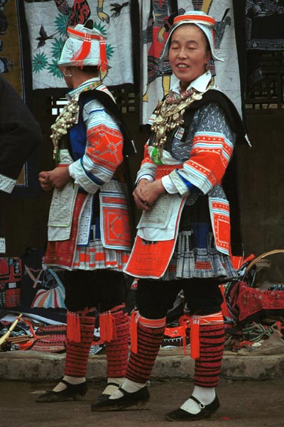 Jpeg 60K 0111G16 Gejia dance troupe performing in Ma Tang village, Kaili City, Guizhou province in November 2001. The apparently wax resist fabric in their costume - at least the headdress, apron and sleeves of the blouse - are now generally made from commercially printed fabric which imitates the Gejia traditional wax resist designs. 