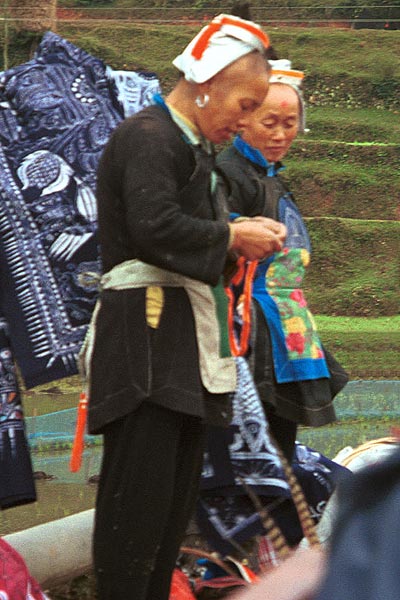 Jpeg 60K 0111G21 Two Gejia women with their modern wax resist for sale to the tourists. Ma Tang village, Kaili City, Guizhou province.