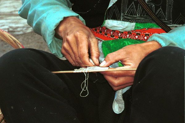 Jpeg 59K 0111G33 Gejia women working on needle knitting the small net which is used to enclose the Gejia women's hair buns - a key part of their identifying headdress still being worn currently even when much of the rest of the costume has been exchange for western clothing. Ma Tang village, Kaili City, Guizhou province. 