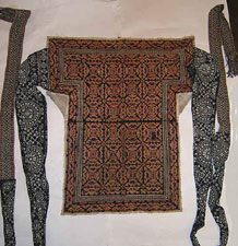 to Jpeg 72K An beautiful embroidered Ge Jia baby carrier from the collection of Bill Hornaday. On the forum he said of this baby carrier: "As to questions regarding Baby Carrier 2 (the one shown above) the wax-resist straps are clearly indigo and seem even darker in real life than the pic. This piece is clearly very old as the straps while old do not seem to be the first set of straps used on the carrier. Because of the quality of the Baby Carrier itself, I would have loved to see the original straps.It seems evident that this piece has been used by multiple generations. It seems as if the silk thread has been faded whether by sun or by washing it is imposible to say. There are definite signs of wear, and one place has a 3/4 inch patch. One has only to feel it to realize that it has a feel that comes from serious age." 