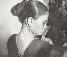 to Jpeg 52K A Ba-sa-dung woman showing her tattoos on face and the back of her neck from the article in the September 1938 National Geographic by Leonard Clark telling of his 5-week trek into the interior of Hainan in the summer of 1937.