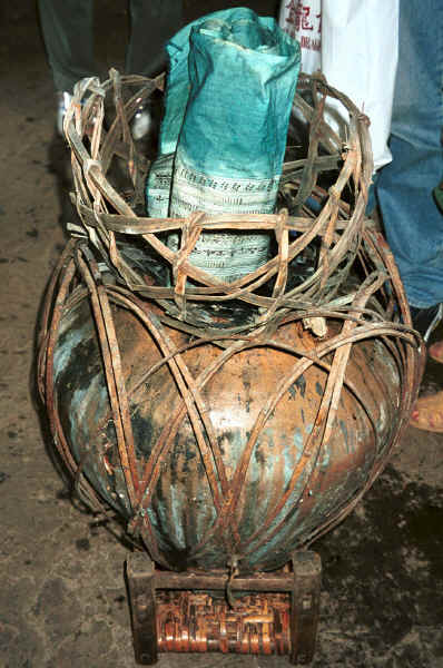 Side comb Miao - a roll of waxed cloth draining and oxidising (for about 10 minutes) over the indigo dye pot after its first of 12 dippings in the dye - Long Dong village, De Wo township, Longlin country, Guangxi province 0010f02.jpg