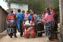 to Jpeg 94K Miao women getting ready to greet with alchohol and lusheng pipes as we enter Lou Jia Zhuang village, Anshun city, Guizhou province. Note the flowers in the wax resist on their festival clothing which may be the reason that are sometimes called 'Flower Miao'. 0110A12