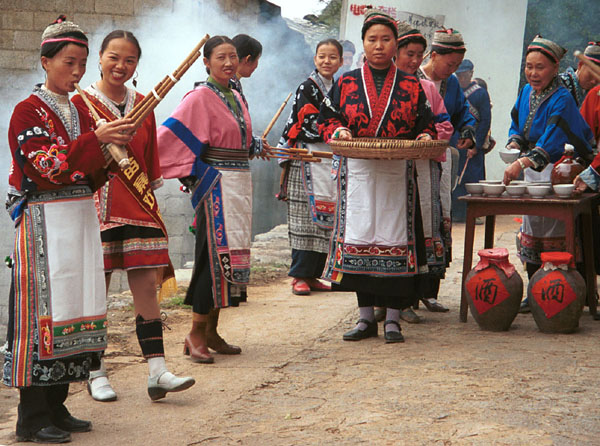 Jpeg 104K Miao women greeting us with alchohol, small carved charms and lusheng pipe music as we enter Lou Jia Zhuang village, Anshun city, Guizhou province. 0110A18