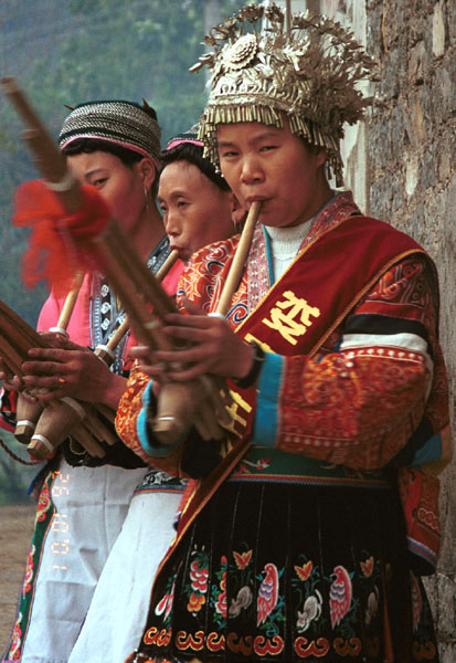 Jpeg 85K The woman near to the camera on the right has a skirt and silver head dress which is not local to this area. It may have been adopted to create more of a stir in the dance competitions or she might have maried into the village from elsewhere. Lou Jia Zhuang village, Anshun city, Guizhou province. 0110A21