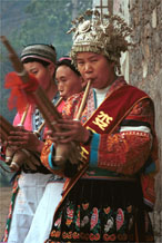 to Jpeg 85K The woman near to the camera on the right has a skirt and silver head dress which is not local to this area. It may have been adopted to create more of a stir in the dance competitions or she might have maried into the village from elsewhere. Lou Jia Zhuang village, Anshun city, Guizhou province. 0110A21