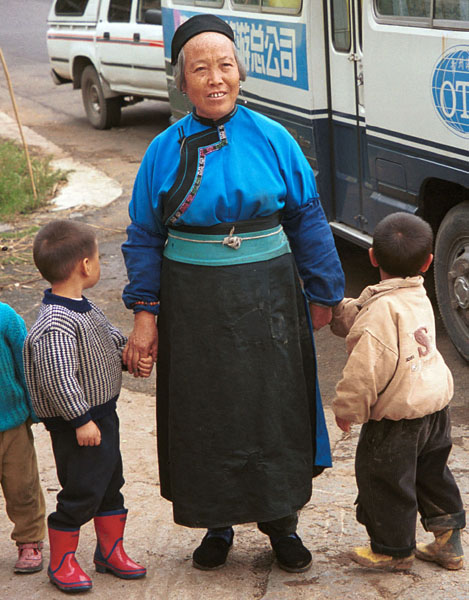 Jpeg 91K Lao Han woman with children come to see what is happening at the Miao village. Note her apron tied with a knot in front. Lou Jia Zhuang village, Anshun city, Guizhou province 0110A29